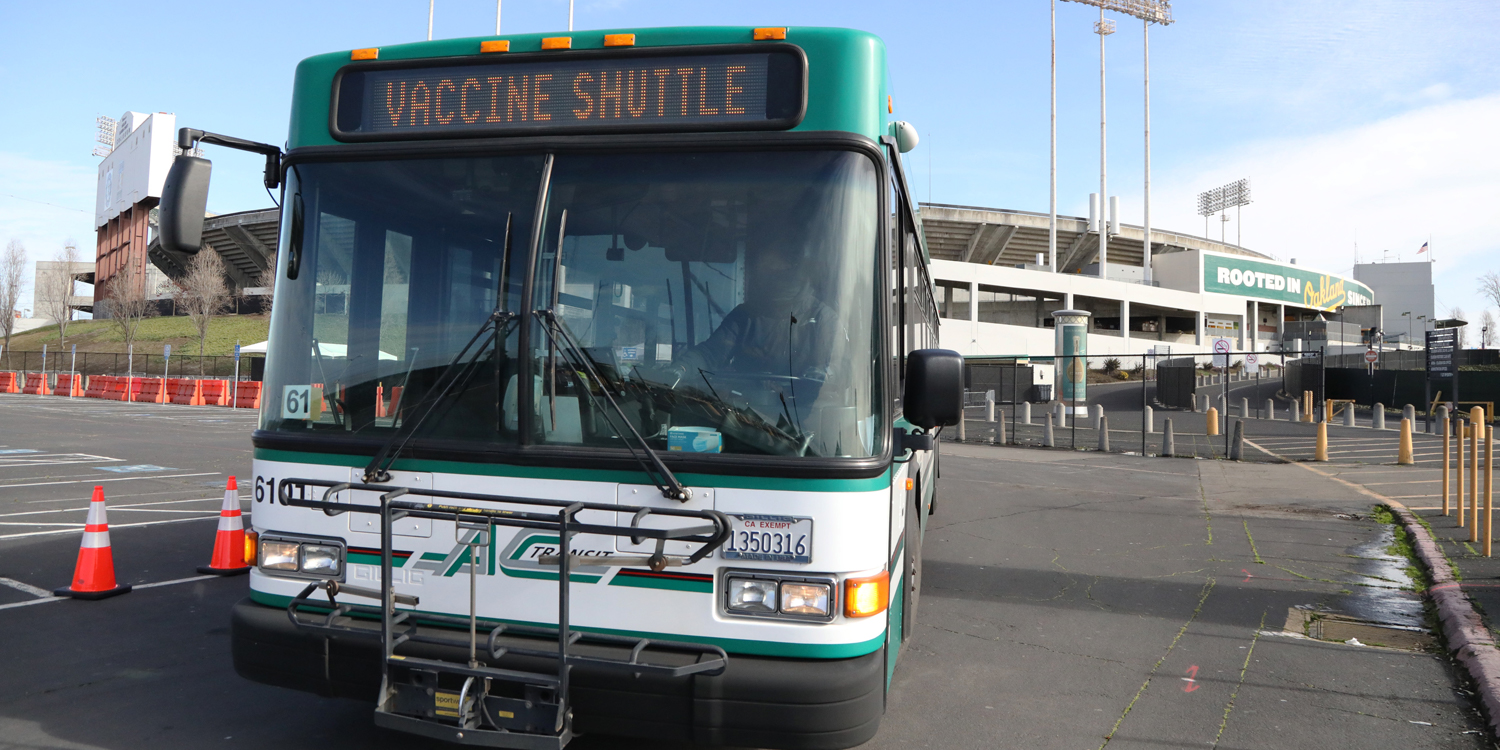 AC Transit Vaccine Shuttle bus with Oakland Coliseum in background