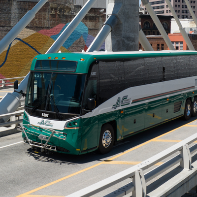 Green Transbay Bus drives over Bay Bridge